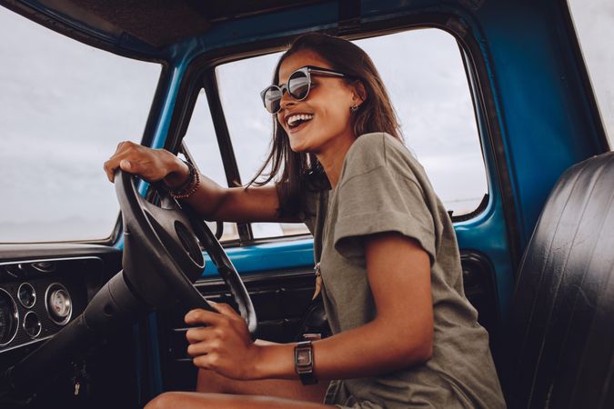 Portrait of young woman having fun while driving a car