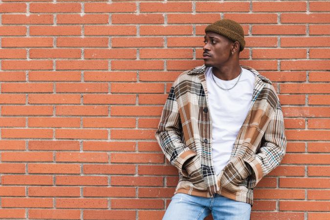 Stylish Black man against brick wall