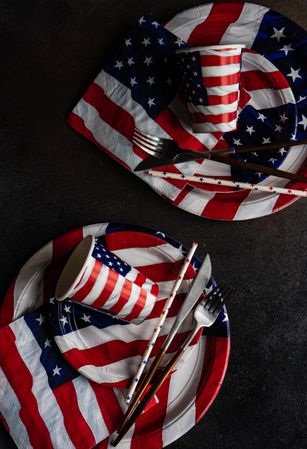 Looking down at American themed flag plates and cups on dark table