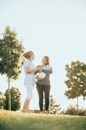 mother and daughter in the park with a baby