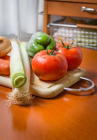 Fresh vegetables on cutting board in the kitchen