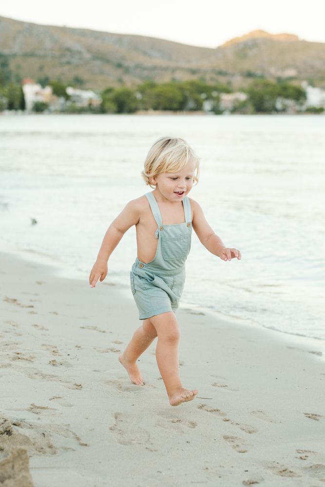 Little boy running on beach in sunny weather