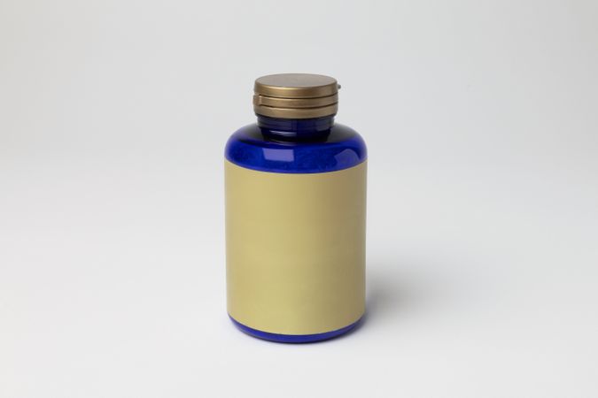 Mockup of a magnesium bottle, food supplement, closed, blue color, with label