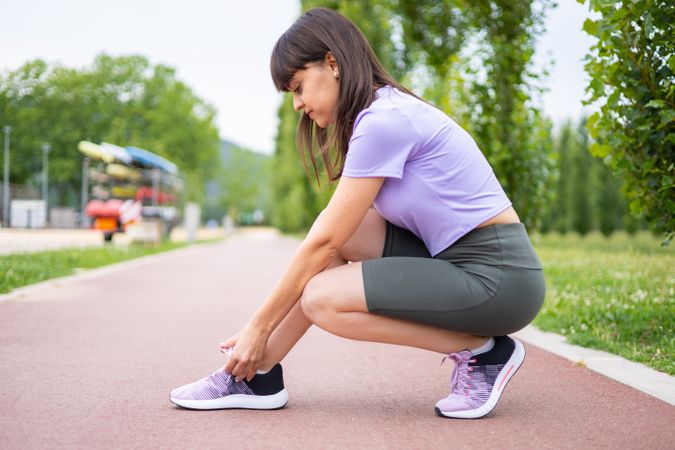 Female athlete tying running shoe laces for running workout