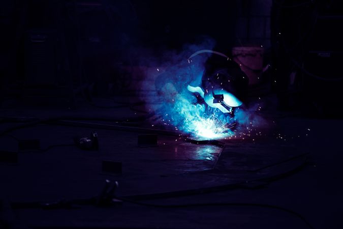 Professional welder in mask welding metal
