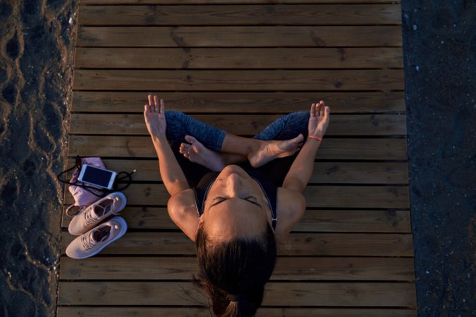 Woman practicing lotus pose on shore