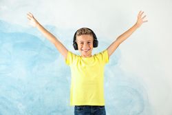 Boy with headphones against color background, space for text