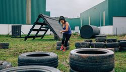 Participant in an obstacle course dragging wheels
