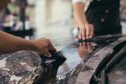 Close up of two men smoothing a car wrap