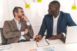 Two businessmen strategizing a project in an office