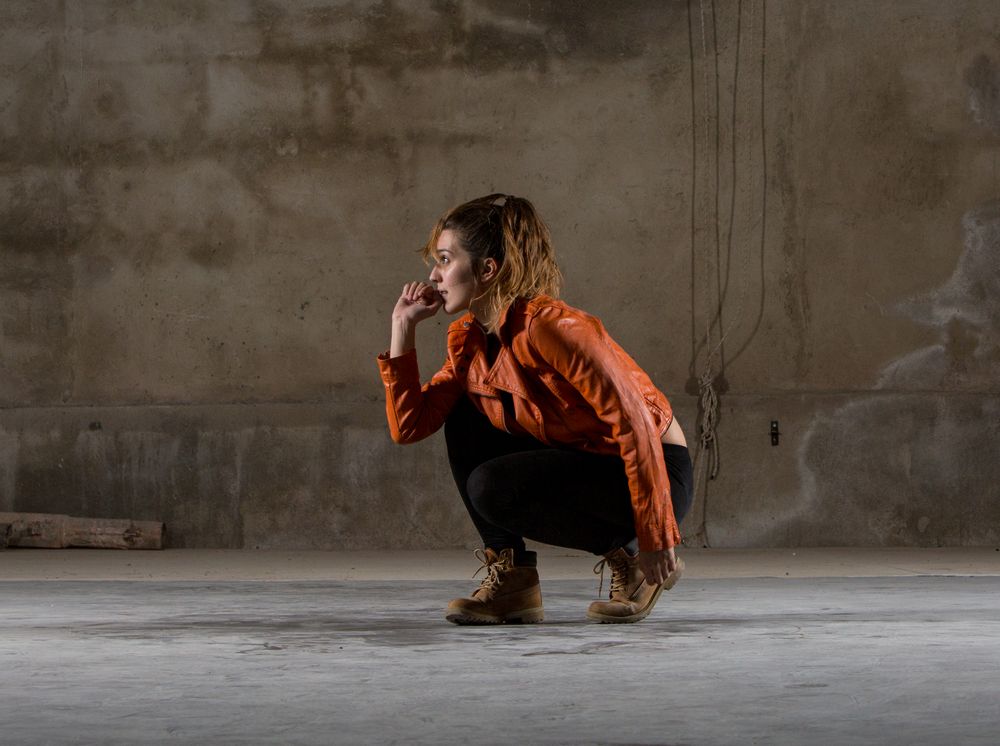 Young woman jumping in grey room
