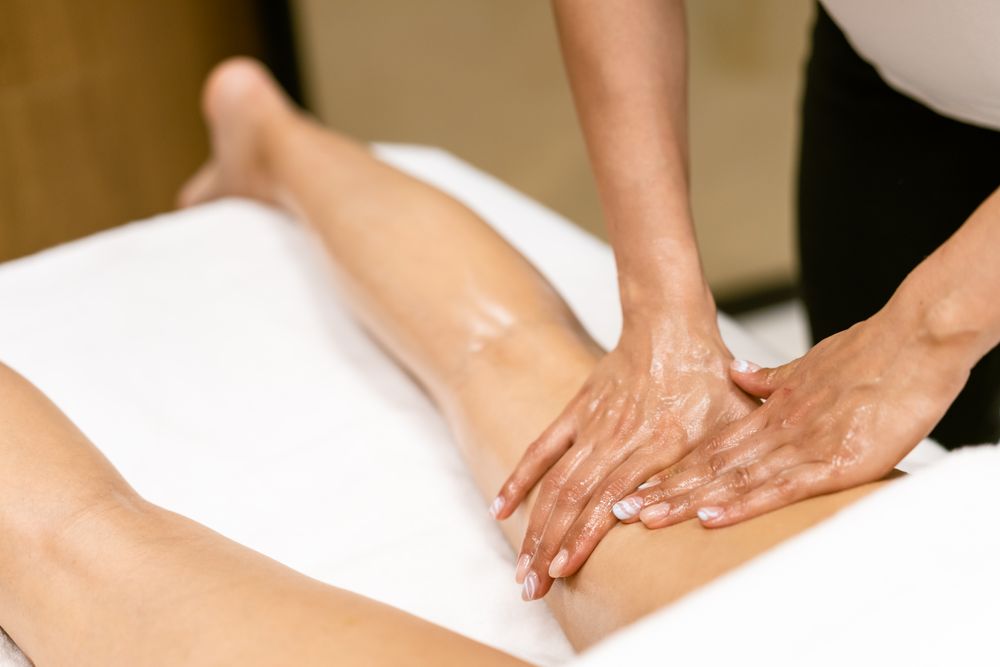 Masseuse giving a leg massage to a female