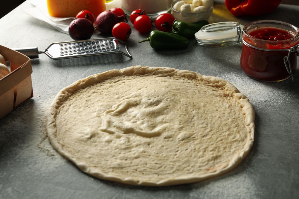 Concept for cooking pizza with ingredients on gray table