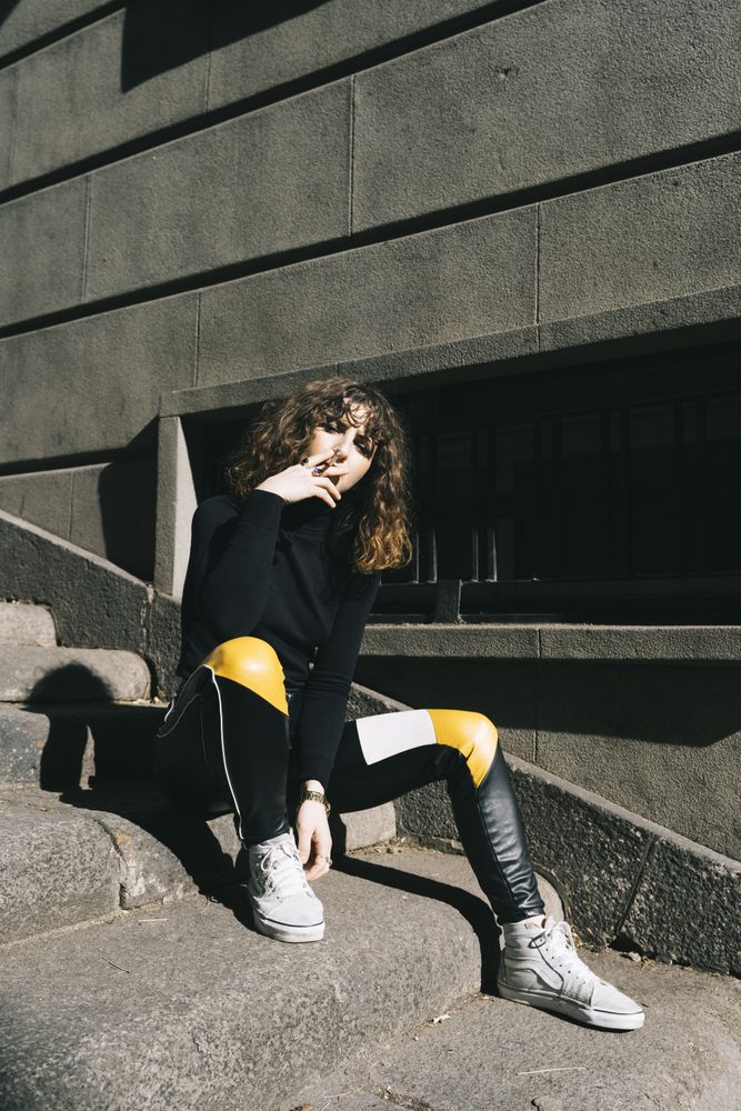Young woman smoking cigarette in the street