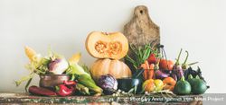 Fresh autumnal produce on kitchen counter, with halved squash and wooden board 4M6eGb