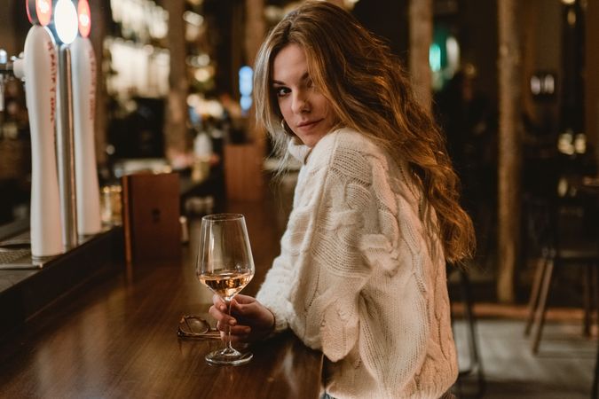 Stylish woman drinking wine in bar