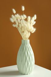 Mint green vase with dried bunny tail bouquet in brown room