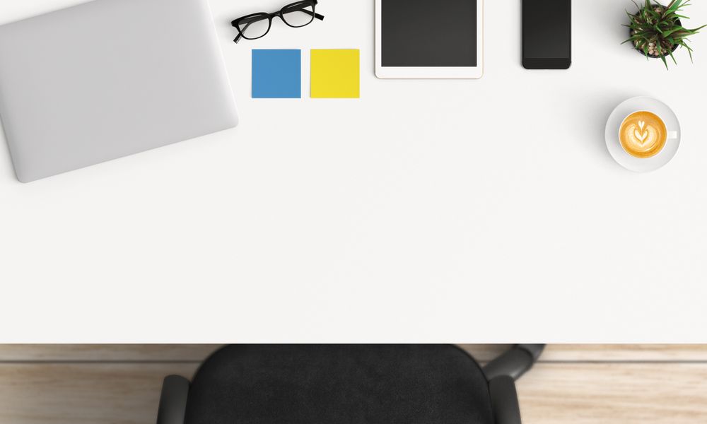 Modern workplace with laptop, coffee cup and smartphone or tablet copy space on table background. Top view. Flat lay style.