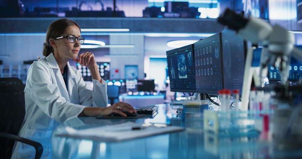 Medical Hospital Research Laboratory: White Female Neurosurgeon Using Computer with Brain Scan MRI Images, Finding Best Treatment for Sick Patient.