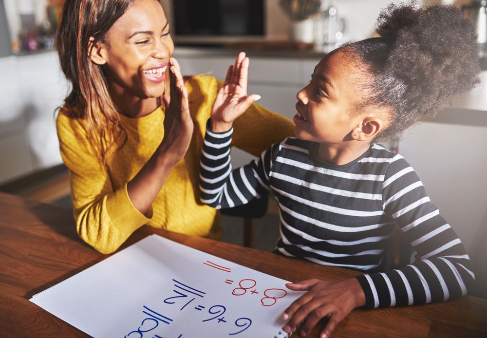 Mother and daughter high five over homework