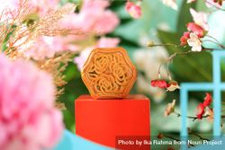 Chinese mooncake with filling surrounded by vibrant flowers 4AkrQ0