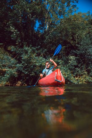 Young female kayaking on nature background