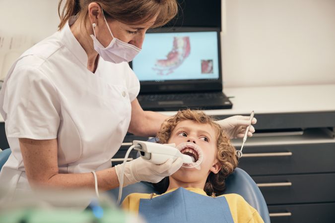 Dentist applying intraoral dental scanner for displaying casts of patient