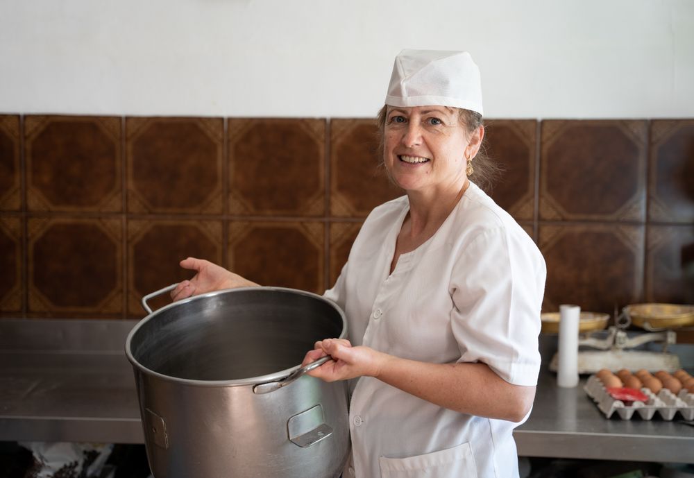 Baker woman smiling with a bakery pan next to egg cartons