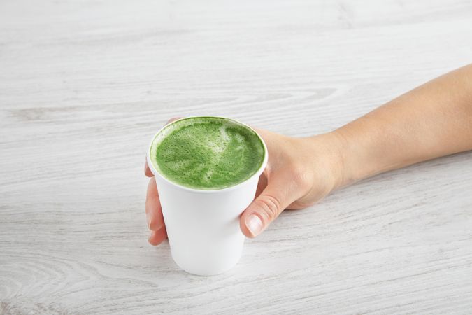 Hand holding a matcha latte