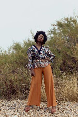 Black woman in colorful shirt standing outdoor