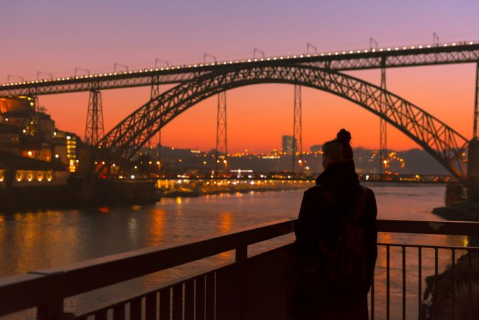 Woman looking at river and city in evening