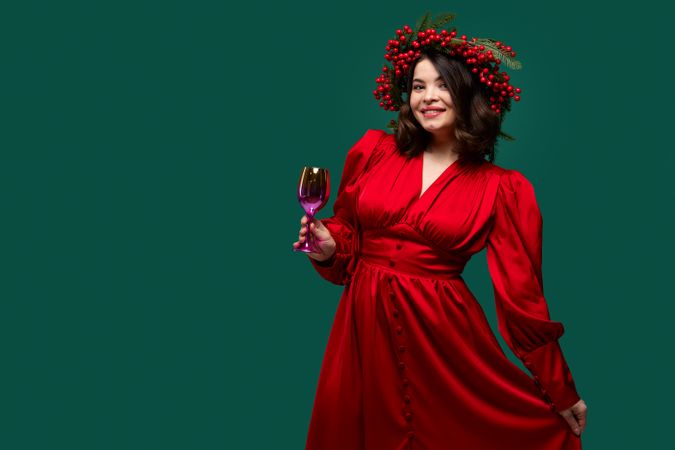 Smiling woman in red dress with berry wreath