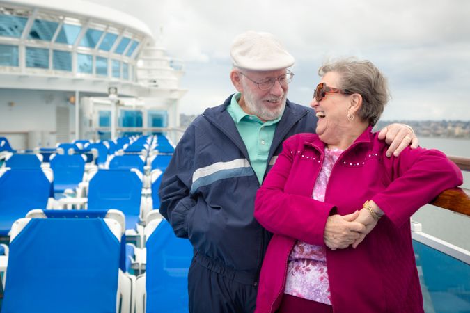 Older Adult Couple Enjoying The View From Their Passenger Cruise Ship Railing.