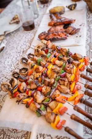 top view of plate with skewers sticks of pork with vegetables and chorizo
