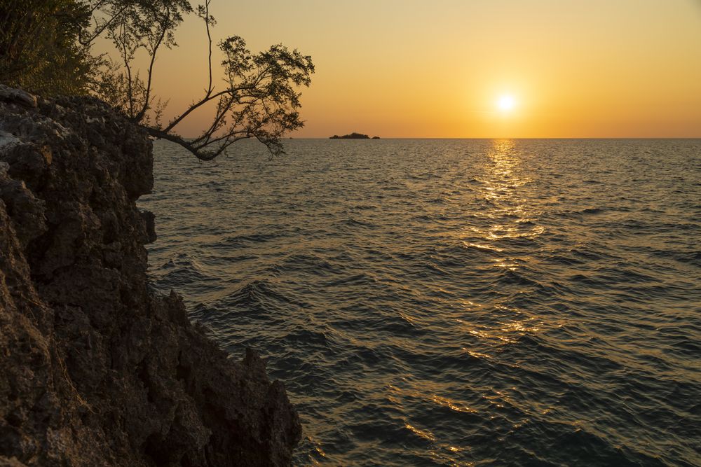 Sunset over the horizon seen from Pulau Poya, one of the islets of the Togian Islands, Indonesia