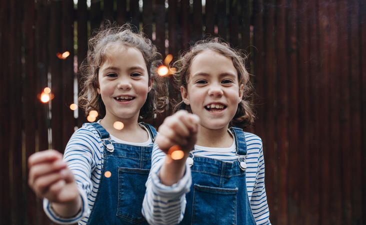 Twin sisters playing with sparklers