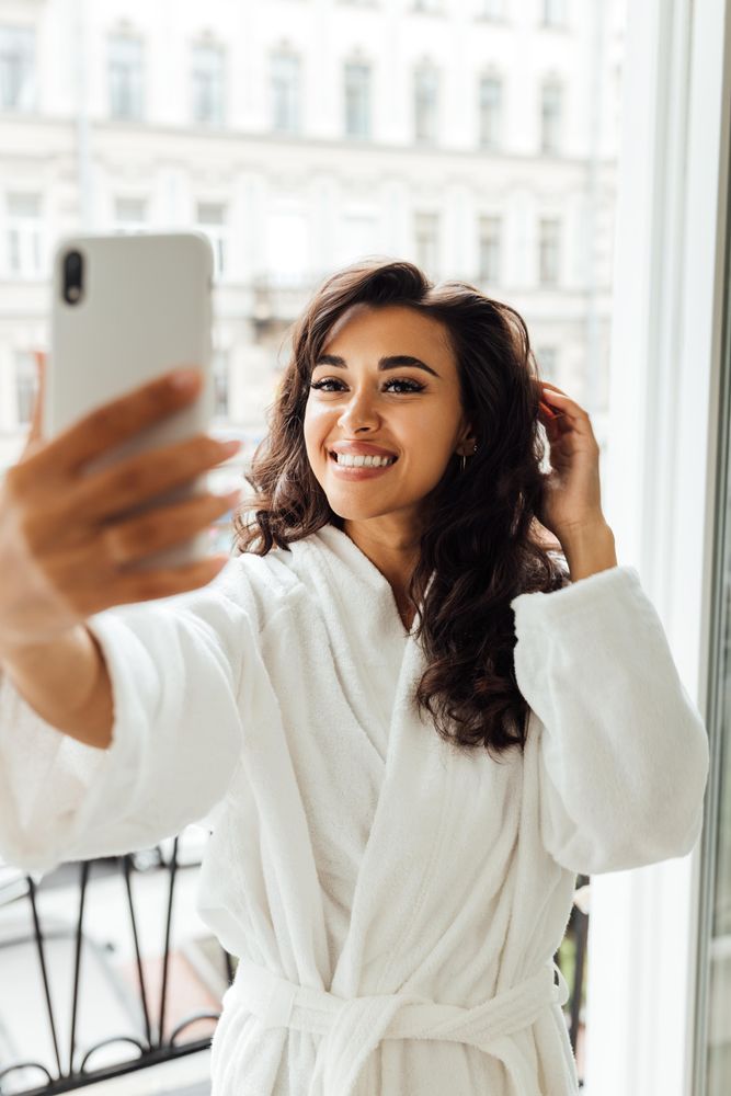 Woman taking a selfie by her window
