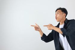 Young Asian Man Gesture Point Finger at Copy Space Portrait