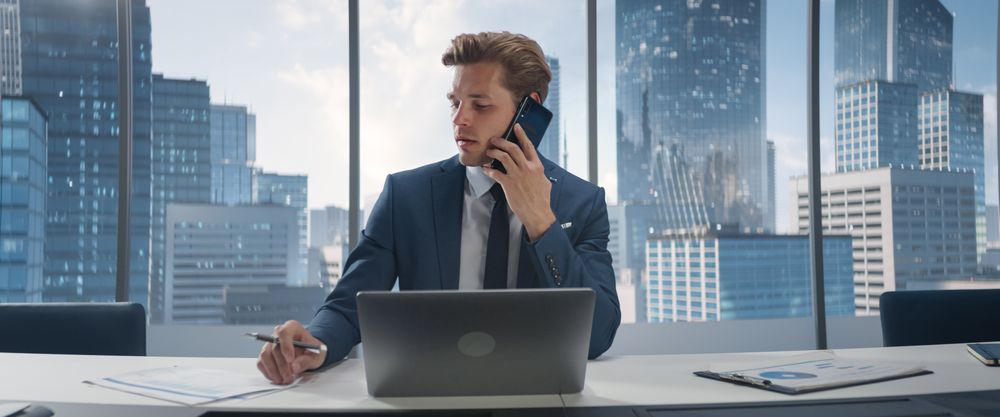 Confident Businessman in a Suit Sitting at a Desk in Office