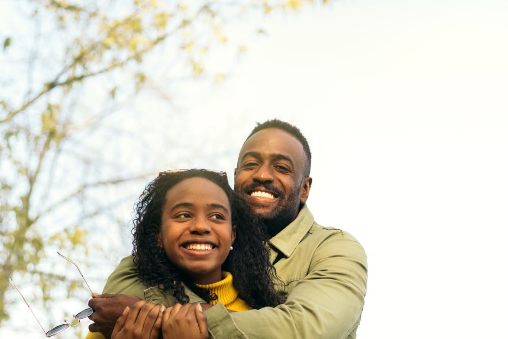 Black couple smiling and hugging
