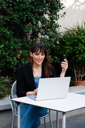 Transgender woman taking a video conference call on a laptop outside