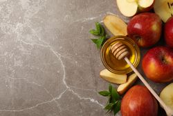 Top view of apples and honey on marble with copy space