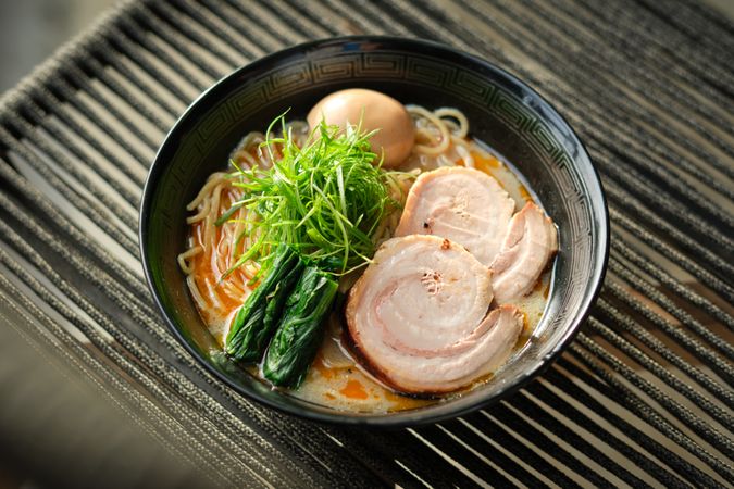 Delicious bowl of ramen soup on chair