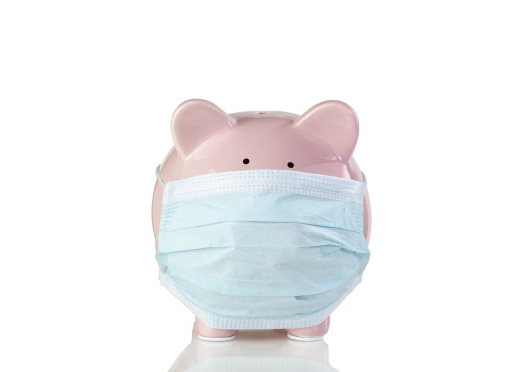 Piggy bank wearing surgical mask isolated on a plain background