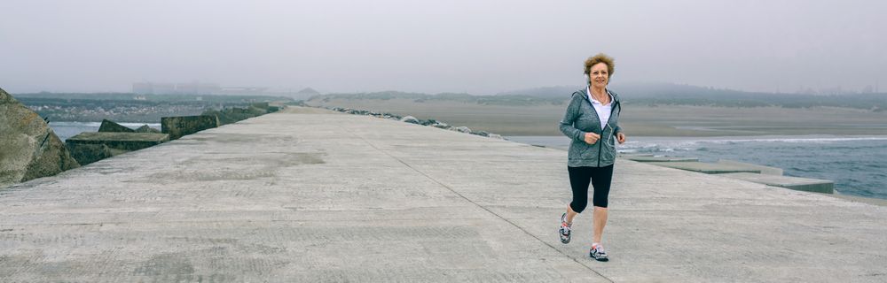 Older woman with headphones running