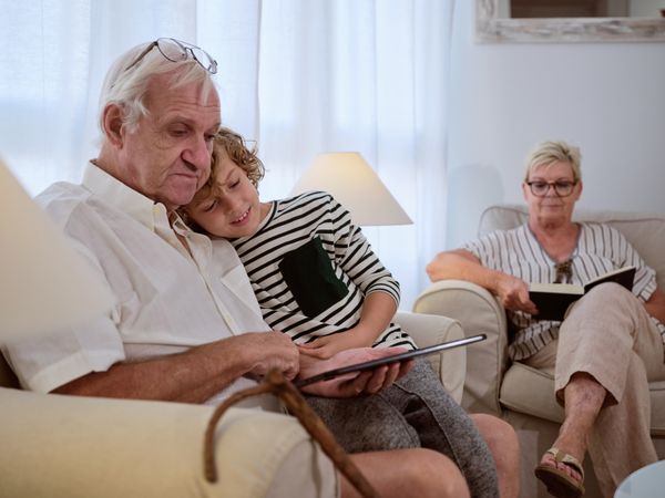 Positive boy with grandfather watching video