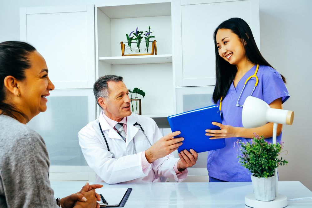 Happy nurse handing doctor patient’s file in office