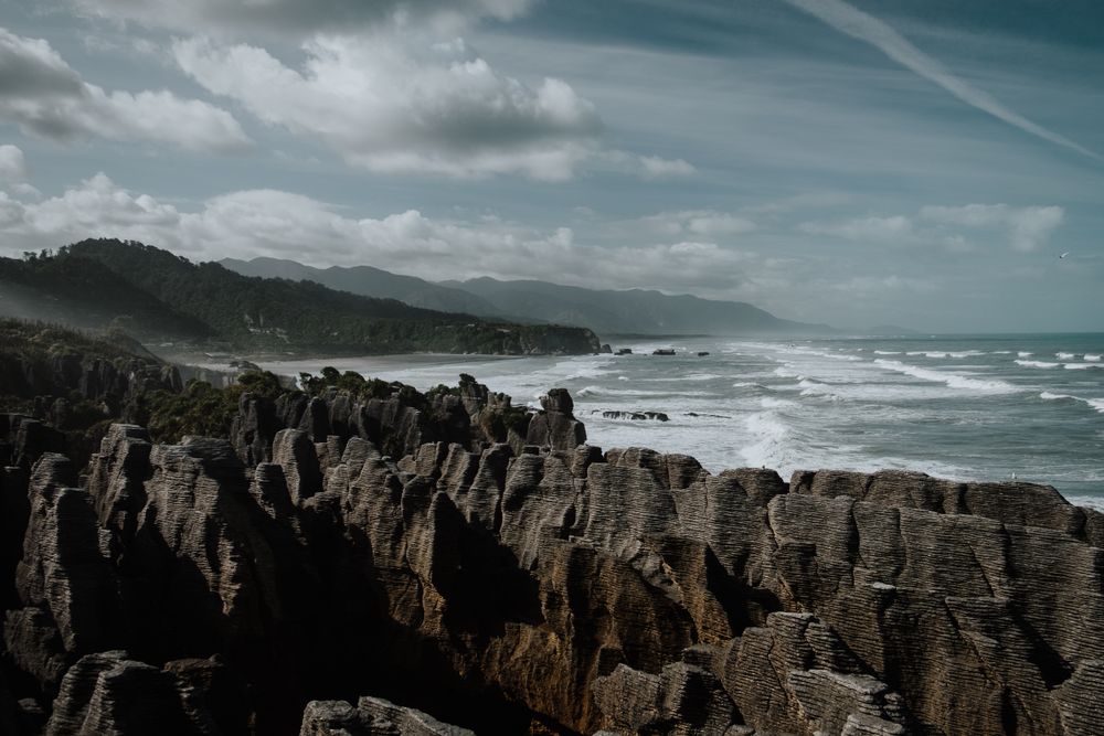 Blue waves washing rocky seashore in bright day