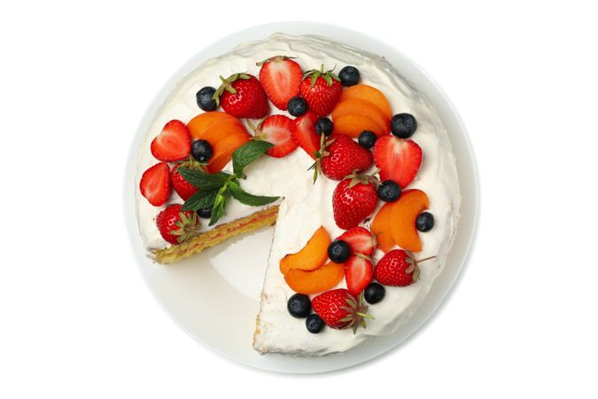 Plate with berry cream cake isolated on plain background