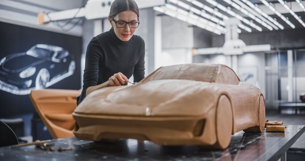 Portrait of a Female Automotive Designer Sculpting a 3D Clay Model of New Production Car.